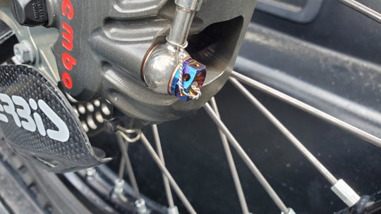 Warp 9 burnt titanium banjo bolt installed on a Brembo front brake caliper
