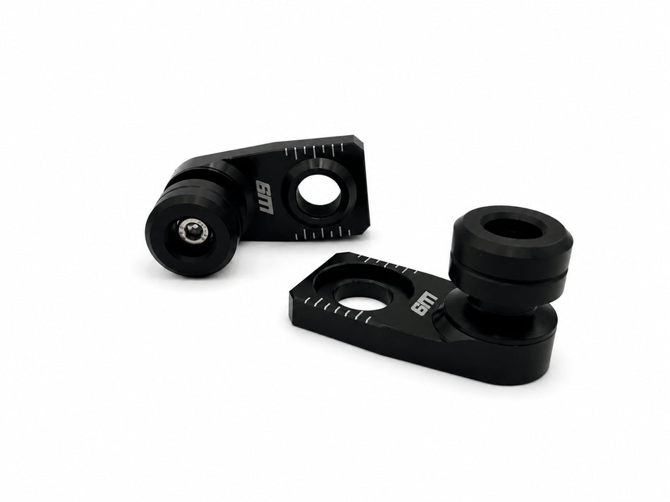 Warp 9 rear axle slider pair: black anodized axle blocks with etched chain alignment marks and black UHMW spools