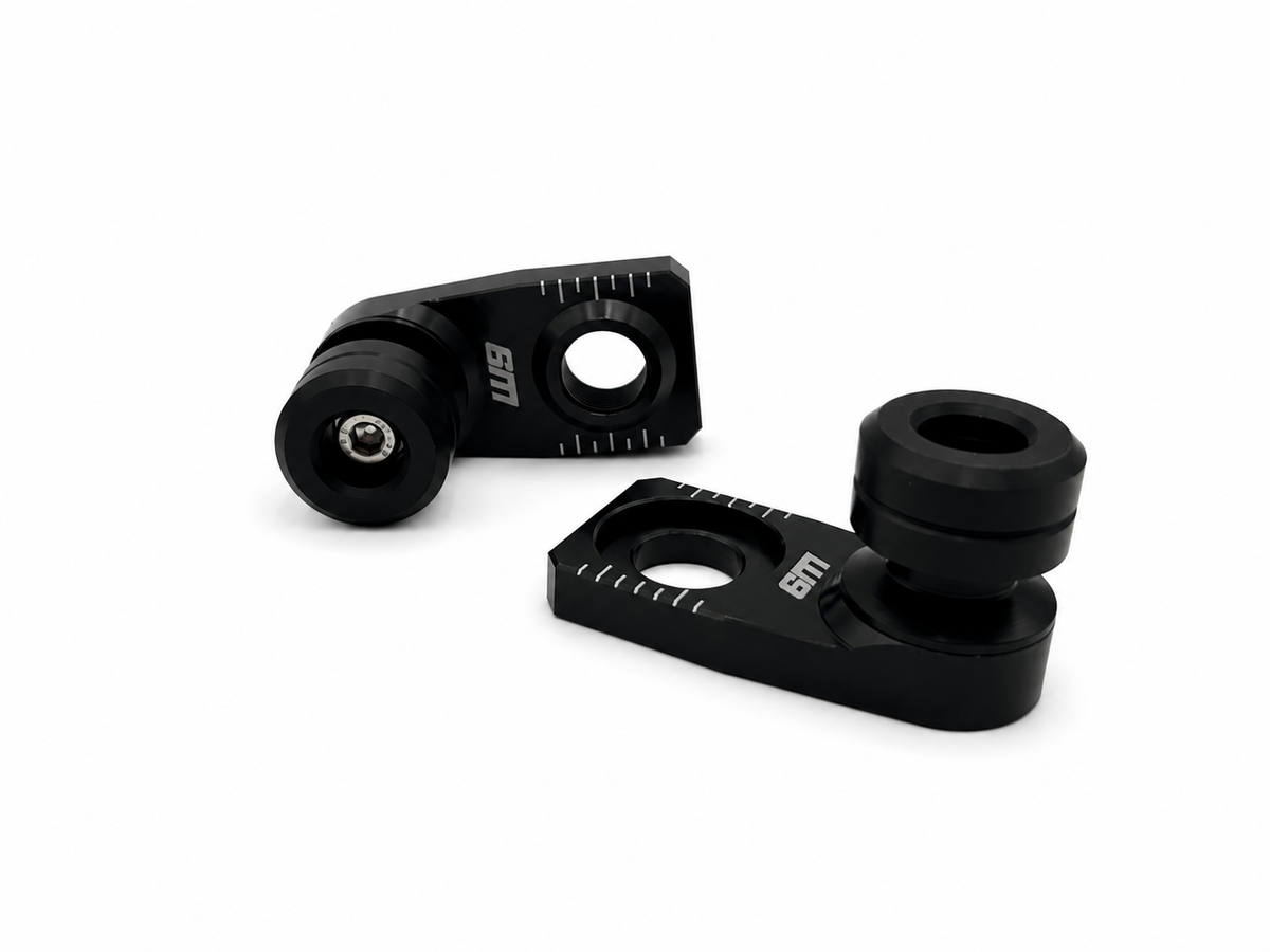 Warp 9 rear axle slider pair: black anodized axle blocks with etched chain alignment marks and black UHMW spools