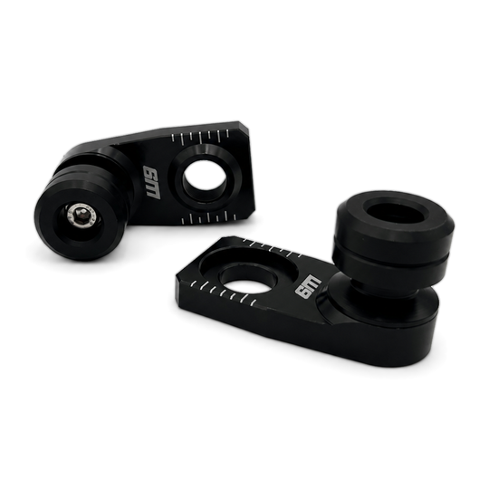 Warp 9 rear axle slider pair: black anodized axle blocks with etched chain alignment marks and black UHMW spools