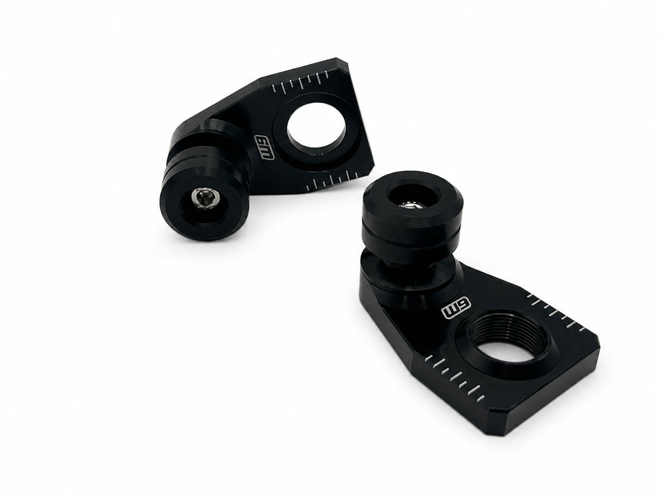 Warp 9 rear axle sliders: angled black anodized adjuster blocks with chain alignment marks and black UHMW spools