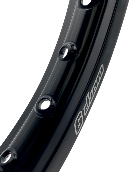 Close-up of a Warp 9 MX/Enduro rim in black anodized aluminum with the Warp 9 logo and spoke holes