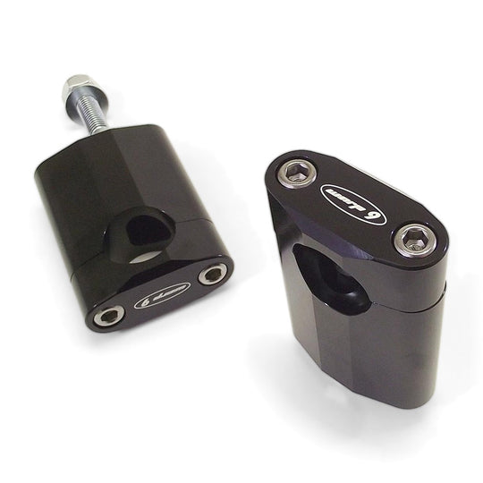 Pair of Warp 9 handlebar risers in black anodized aluminum with the Warp 9 logo and mounting bolt