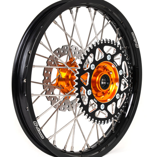 Warp 9 rear wheel with an orange hub, black rim, silver spokes, black sprocket and a drilled brake rotor
