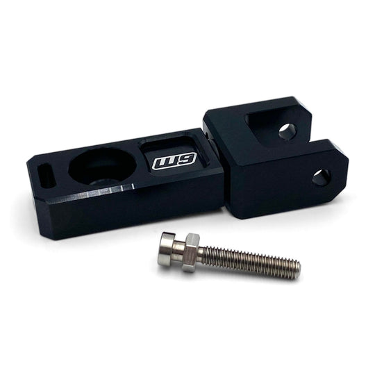 Warp 9 e-moto trailer mount, a black aluminum axle block with a hitch tab and a stainless bolt