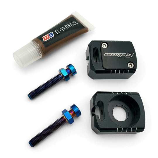 Warp 9 Lockdown axle blocks in black anodized aluminum with two burnt titanium adjuster bolts and titanium anti-seize