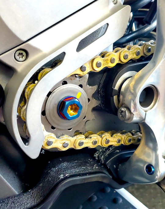 Warp 9 burnt titanium countershaft bolt installed on a Stark Varg front sprocket