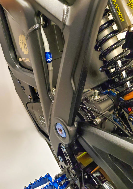 Warp 9 gearcase vent installed on a Talaria Sting, a blue anodized W9 check valve on the breather tube